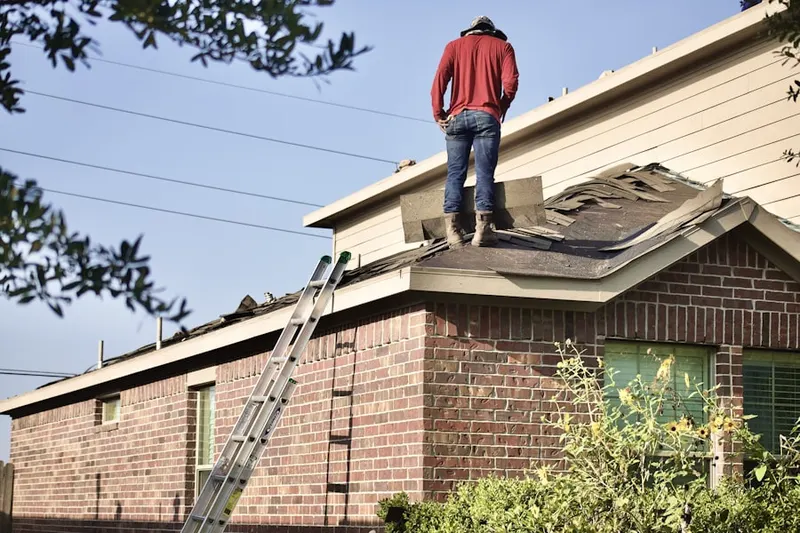 Professional roofer working on a residential roof in Lee Center
